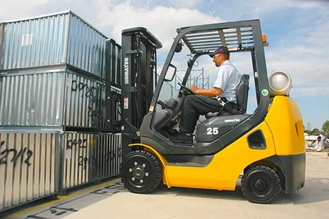 Man Operating Forklift to Lift Containers